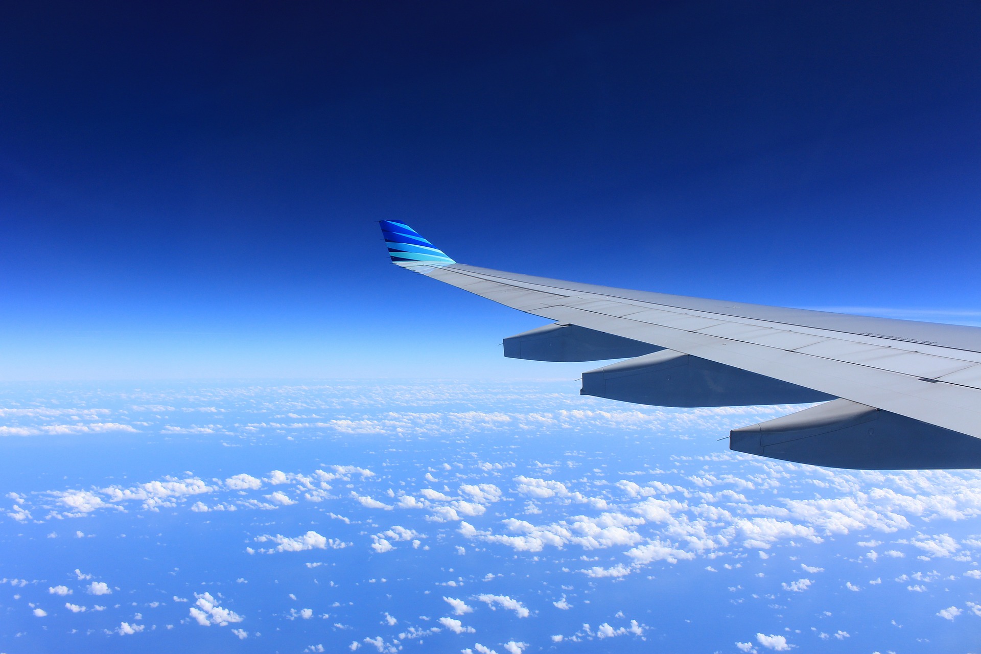 photo of airplane wing against blue sky