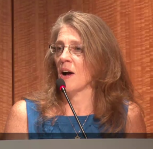 Cynthia Hallett speaking at a podium