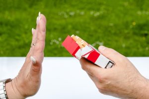 Photo of a woman's hand held out against an offered pack of cigarettes